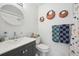 Bright bathroom with modern vanity, round mirror, decorative wall art, and neutral color scheme at 9400 E Iliff Ave # 145, Denver, CO 80231