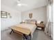 Bedroom featuring a ceiling fan, window, wall decor, bedside tables, and bedside lamps at 9400 E Iliff Ave # 145, Denver, CO 80231