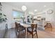 Charming dining area with hardwood floors, modern lighting, and a view to the updated kitchen at 9400 E Iliff Ave # 145, Denver, CO 80231