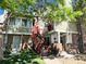 Inviting condo featuring brick accents, red stairs, and lush tree shading the exterior at 909 S Dawson Way # 19, Aurora, CO 80012