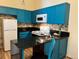 Bright kitchen featuring modern blue cabinets, tiled backsplash, and sleek countertops at 909 S Dawson Way # 19, Aurora, CO 80012