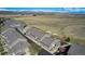 Aerial view showcases the townhome community's layout, green spaces, road access, and mountain views at 4739 Raven Run, Broomfield, CO 80023