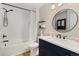 Stylish bathroom with a shower-tub combo, modern fixtures and a blue vanity at 4739 Raven Run, Broomfield, CO 80023