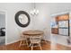 Cozy dining area with a round table, stylish chandelier, and hardwood floors, adjacent to the kitchen at 4739 Raven Run, Broomfield, CO 80023
