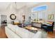 Bright and airy living room featuring large windows, vaulted ceilings, and beautiful hardwood floors at 4739 Raven Run, Broomfield, CO 80023