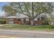 Charming brick home with a large tree, a red front door, and an attached garage offers great curb appeal at 2201 S Lowell Blvd, Denver, CO 80219