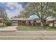 Charming brick home with a large tree, a red front door, and an attached garage offers great curb appeal at 2201 S Lowell Blvd, Denver, CO 80219