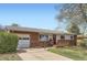 Single-story brick home with attached garage and a cozy front porch, perfect for curb appeal at 2201 S Lowell Blvd, Denver, CO 80219