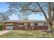 Charming single-story brick home with a well-manicured front lawn and inviting wooden porch at 2201 S Lowell Blvd, Denver, CO 80219