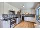 Modern kitchen with stainless steel appliances, granite countertops, and white cabinets offers sleek design at 2201 S Lowell Blvd, Denver, CO 80219