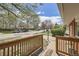 View from the wooden front porch railings of a charming neighborhood street lined with trees and homes at 2201 S Lowell Blvd, Denver, CO 80219