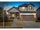 Dusk view of a charming two-story home with a well-manicured lawn and inviting front porch at 10788 Ventura St, Commerce City, CO 80022