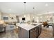 Modern kitchen with stainless steel appliances, island and open floor plan at 10788 Ventura St, Commerce City, CO 80022