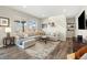 Bright living room with large windows, a sectional sofa, and hardwood floors at 10788 Ventura St, Commerce City, CO 80022