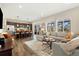 Open-concept living room and kitchen with a large sectional sofa and a kitchen island at 10788 Ventura St, Commerce City, CO 80022