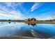 Beautiful pond reflecting a community building with a clear blue sky, creating a serene setting at 10788 Ventura St, Commerce City, CO 80022