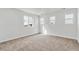 A bright bedroom featuring three large windows, neutral walls, and carpet flooring at 9092 Telluride Ct, Commerce City, CO 80022