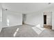 A bright bedroom featuring an attached door and neutral carpet at 9092 Telluride Ct, Commerce City, CO 80022
