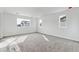 A bright bedroom featuring windows with a view of neighborhood homes and neutral carpet at 9092 Telluride Ct, Commerce City, CO 80022