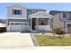 Charming two-story home with a covered porch, gray siding, and a well-maintained front yard at 9092 Telluride Ct, Commerce City, CO 80022