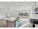 Bright, open kitchen with a central island, stainless steel appliances, and sliding glass doors at 9092 Telluride Ct, Commerce City, CO 80022