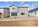 View of the backyard and the rear of the two-story home with gray siding and sliding glass door at 9092 Telluride Ct, Commerce City, CO 80022