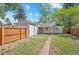 View of backyard with a gray house, a detached garage, and a wooden fence at 1177 Wabash St, Denver, CO 80220