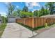 Long driveway leading to detached garage and backyard with tall wooden fence at 1177 Wabash St, Denver, CO 80220