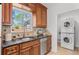 This kitchen features stainless steel appliances, granite countertops, and washer and dryer in hall at 1177 Wabash St, Denver, CO 80220