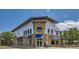 Exterior view of a modern restaurant with stone accents and a blue awning at 14567 W 90Th Ln # B, Arvada, CO 80005