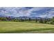 Scenic golf course view with lush green grass, trees, and distant mountain range at 14567 W 90Th Ln # B, Arvada, CO 80005