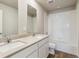 Bright bathroom with a double vanity, shower and bath with white tile at 48260 Shetland Dr, Bennett, CO 80102