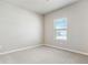 Bedroom with carpet, white walls and a large window overlooking the neighborhood at 48260 Shetland Dr, Bennett, CO 80102