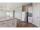 Open concept kitchen with stainless steel refrigerator, white cabinetry and island at 48260 Shetland Dr, Bennett, CO 80102