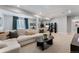 Open basement area features plush carpeting, modern lighting, and comfortable sectional sofa at 3444 Recess Pt, Castle Rock, CO 80108