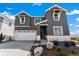 Attractive two-story home featuring gray siding, white brick accents, and an attached two-car garage at 3444 Recess Pt, Castle Rock, CO 80108