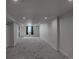 Finished basement with recessed lighting, neutral carpet, and a large window at 3360 Magnolia St, Denver, CO 80207