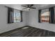 This bedroom features new hardwood floors, a ceiling fan, and two windows providing great natural light at 3360 Magnolia St, Denver, CO 80207