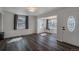 Living room featuring dark hardwood flooring, large window, and white front door at 3360 Magnolia St, Denver, CO 80207