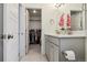 Bathroom featuring modern grey cabinetry, double sink, tile flooring and open view to the walk in closet at 4138 N Quatar Ct, Aurora, CO 80019