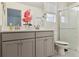 Bathroom featuring double sink, walk in shower with glass door, tile flooring and pink floral decor at 4138 N Quatar Ct, Aurora, CO 80019