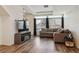 Cozy living room featuring a comfortable sofa, large windows with blinds, and wood-like flooring, creating a relaxing atmosphere at 4138 N Quatar Ct, Aurora, CO 80019