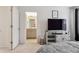 Bright main bedroom featuring modern television, bedside table, and an open door to the ensuite bathroom at 4138 N Quatar Ct, Aurora, CO 80019