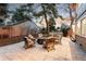 Backyard patio featuring a stone paver patio, outdoor furniture set, and mature tree for shade at 2867 S Oswego Ct, Aurora, CO 80014