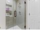 Modern bathroom shower with gray subway tile, glass door, and white hexagon tile floor at 2867 S Oswego Ct, Aurora, CO 80014