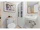 Bathroom featuring classic white fixtures, a mirror, and a storage cabinet at 2867 S Oswego Ct, Aurora, CO 80014