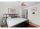Cozy bedroom featuring a patterned accent wall, black bed frame, and hardwood floors at 2867 S Oswego Ct, Aurora, CO 80014
