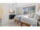 Bright bedroom featuring a large window, modern light fixture, and mounted flatscreen TV at 2867 S Oswego Ct, Aurora, CO 80014