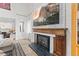 Bright living room fireplace with white brick and a wooden mantel and herringbone tile at 2867 S Oswego Ct, Aurora, CO 80014