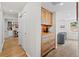 Hallway view showcasing wood floors, built-in wooden cabinets, and the doorway to a bright, cheerful study area at 2867 S Oswego Ct, Aurora, CO 80014